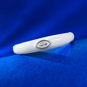Dettaglio macro di pietra marquise su anello smaltato bianco dal design minimalista
