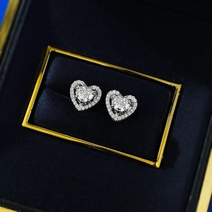 Macro shot of S925 silver heart halo stud earrings with diamond accents in a blue gift box