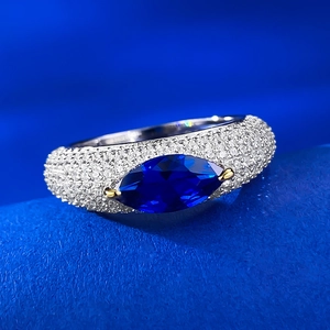 Detailed macro view of marquise cut blue gemstone ring with pave set sparkling diamonds