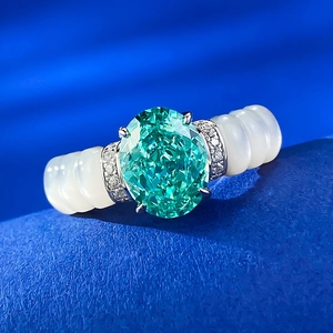 Bague en argent S925 avec pierre verte ovale et anneau ondulé blanc sur fond bleu