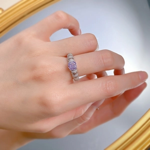 Macro shot of silver ring featuring a large square purple gemstone and pavé-set band lines