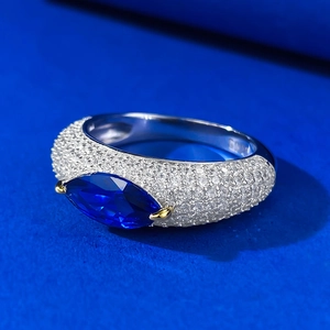 Detailed macro shot of a marquise-cut deep blue gemstone set in a pavé diamond silver ring