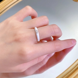 Primo piano di anello impilabile in smalto bianco con zircone taglio marquise sul dito