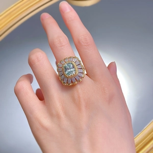 Macro detail of luxury cocktail ring featuring green gemstone and intricate gold band