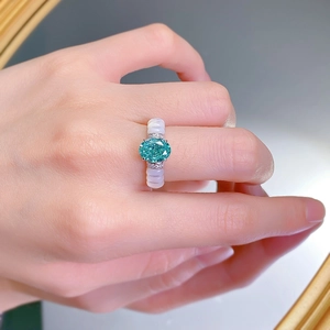 Gros plan d'une bague en argent S925 avec gemme Paraïba et anneau en céramique