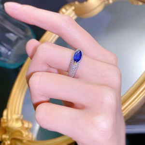 Detail of s925 silver gold-plated ring featuring a marquise blue gemstone and pavé diamonds