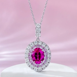 Macro shot of oval rose red gemstone pendant necklace with double diamond halo