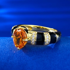 Macro d'une bague à pierre orange ovale avec émail noir et accents de diamants