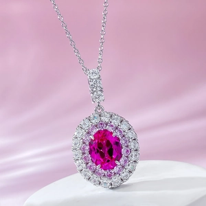 Macro detail of oval pink gemstone pendant with double halo diamond setting on silk