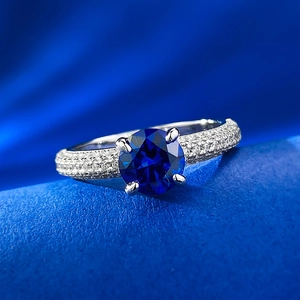 Detail of S925 silver ring featuring one-carat round blue sapphire and pavé diamonds