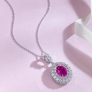 Macro detail of oval pink gemstone necklace with double-layered halo diamond setting