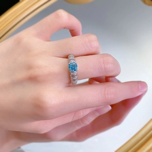 Close-up of a 925 silver ring with a blue square gemstone and pavé diamonds on hand