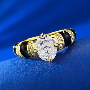 Macro view of oval white diamond ring with gold plating and black enamel details