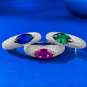 Detailed macro shot of three marquise cut rings with emerald, sapphire, and ruby gems