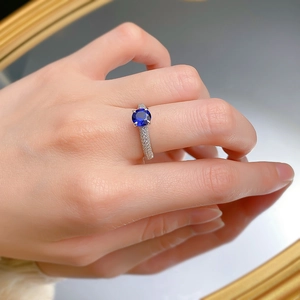 Macro detail of luxury S925 silver ring featuring a blue sapphire with pavé set diamonds