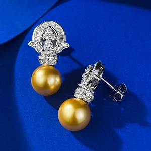 Macro detail of 11mm golden pearl stud earrings with 925 silver crown diamond setting