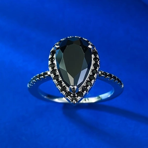 Elegant 925 sterling silver ring featuring a pear-cut black zircon stone on blue background