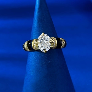 Macro shot of gold oval-cut diamond ring with black enamel and micro-pave detailing