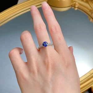 Close-up of S925 silver ring with 1-carat round blue sapphire and pavé diamonds
