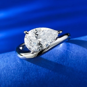 Detailed view of pear cut diamond ring with minimalist wave band in polished S925 silver