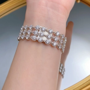 Close-up of a three-row tennis bracelet with sparkling round-cut crystals in silver finish