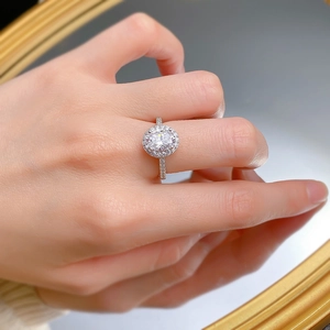 Detailed close-up of a 925 silver oval halo ring with sparkling pavé-set stones on hands