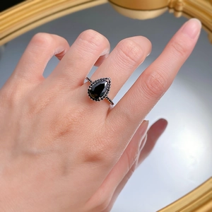 Detail of 925 silver ring with pear-shaped black zircon stone worn on finger