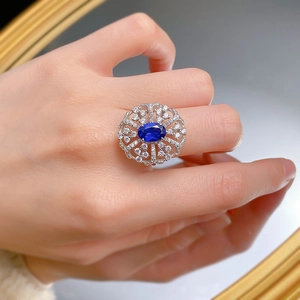 Close-up of a 925 silver ring with a royal blue oval stone and hollow floral pavé setting