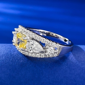 Detailed view of square yellow gemstone ring with pear-cut side stones on blue stand
