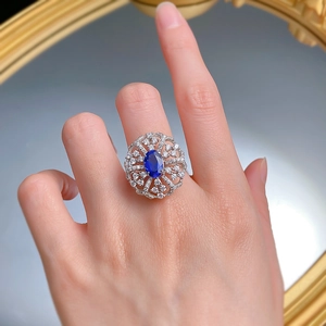Detailed view of luxury 925 silver ring with large oval blue sapphire and pavé diamonds