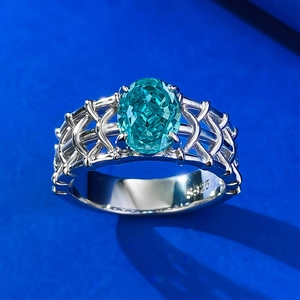 Bague en argent S925 avec pierre Paraiba ovale et anneau tressé sur fond bleu pur
