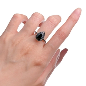 Pear cut black zircon halo ring in rose gold with pavé diamonds on finger