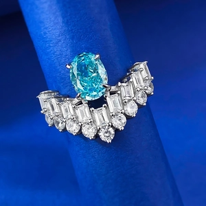 Macro detail of oval light blue gemstone ring with crown-style sparkling diamond accents