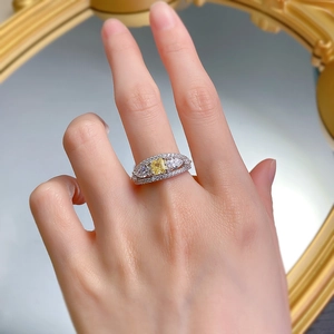 Close-up of radiant yellow diamond ring with side stones and paved crystals on finger