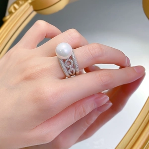 Macro detail of a 12mm white shell pearl ring with pavé set zircon accents on a silver band