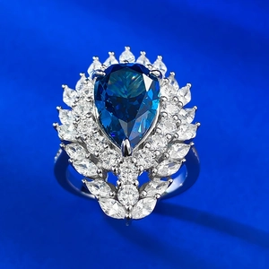 Macro shot of 925 sterling silver ring with pear-cut royal blue stone and halo diamonds