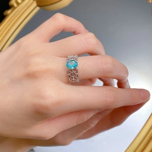 Gros plan d'une bague en argent S925 avec tourmaline paraiba ovale et anneau tressé