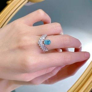 Close-up of Paraiba blue gemstone ring with V-shaped diamond setting on finger