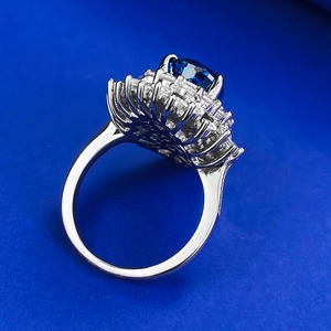 Macro detail of royal blue pear-shaped silver ring with halo of tapered baguette diamonds