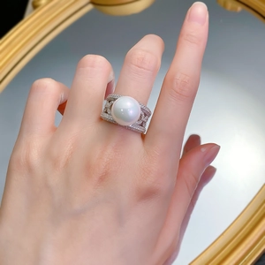 Macro detail of a 12mm white pearl ring with a wide S925 silver micro-pave hollow band