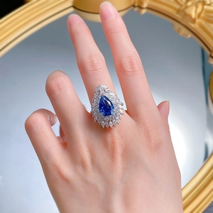 Close-up of 925 sterling silver ring with pear-cut blue stone and marquise cubic zirconia