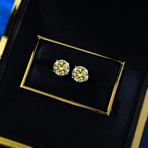 Close-up of yellow gemstone stud earrings with silver four-prong setting in a jewelry box