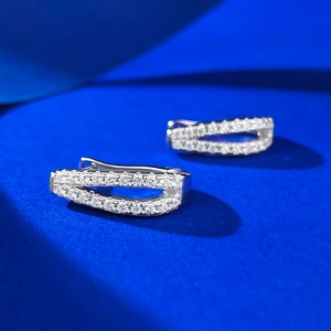 Macro detail of S925 silver crossover earrings with sparkling pavé cubic zirconia
