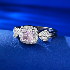 Détail macro d'une bague avec pierre carrée rose et accents de diamants en forme de cœur
