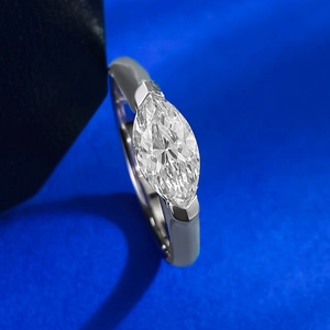 Macro detail of marquise-cut zirconia ring in silver finish on blue velvet background