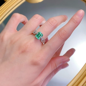 925 silver ring with rectangular emerald green gemstone worn on middle finger