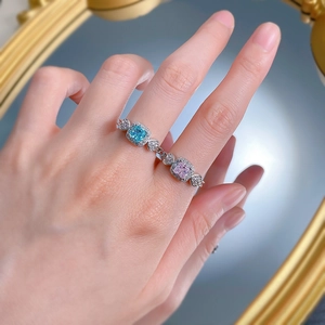 Gros plan sur une bague en argent S925 avec pierres rose et bleu et détail de cœur ciselé