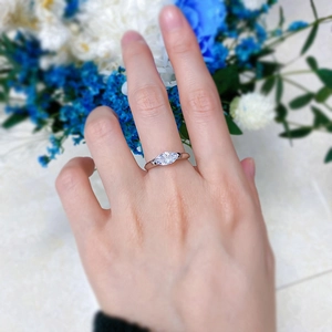 Detailed view of a marquise-cut zircon ring on finger with modern minimalist silver band