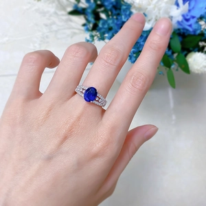 Macro detail of S925 silver ring featuring an oval blue sapphire and pavé diamonds