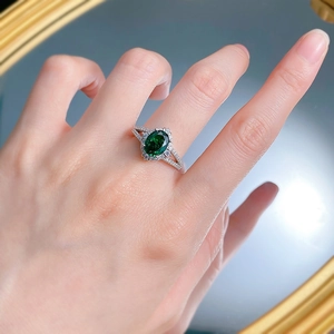 Elegant S925 silver ring with oval emerald-cut green gemstone on a model's hand